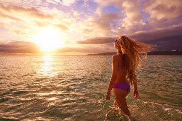Carefree woman in the sunset on the beach.