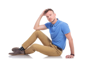 pensive young man sitting on the floor