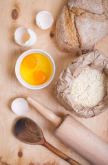 Baking ingredients - egg, eggshell, flour, rolling pin, spoon