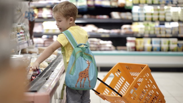 Boy putting products into shopping cart