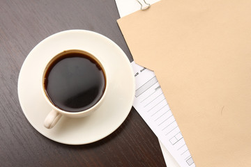 A folder with papers and a cup of coffee on a desk