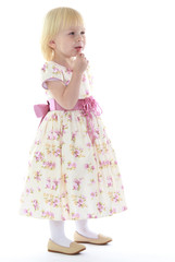 Thoughtful little girl in a long dress.