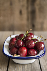 Cherries in rustic kitchen setting with wooden background