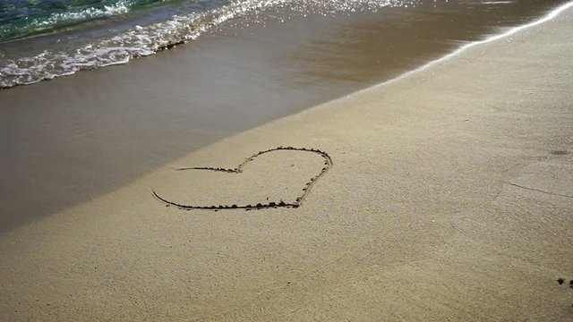 romantic heart painted in sand beach