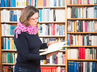 Frau liest vor B&uuml;cherwand