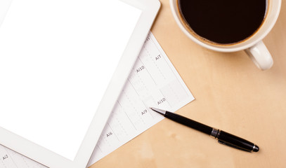 Tablet pc with empty space and a cup of coffee on a desk