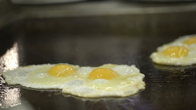 Two portions of fried eggs cooked on the stove