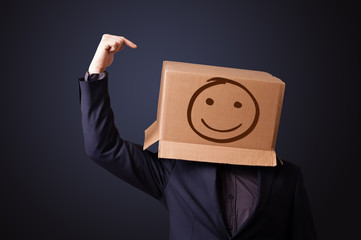 Young man gesturing with a cardboard box on his head with smiley