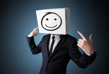 Businessman gesturing with a cardboard box on his head with smil