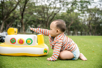 Baby playing on the grass field in the park