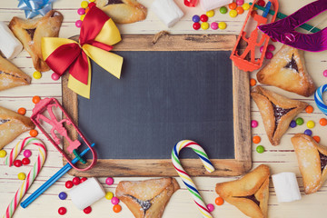 Hamantaschen cookies and chalkboard on wooden white table