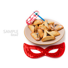 Hamantaschen cookies on plate and carnival mask