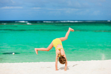 Fototapeta na wymiar Cute little girl having fun on beach vacation