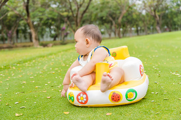 baby sit on the seat at the green grass field park