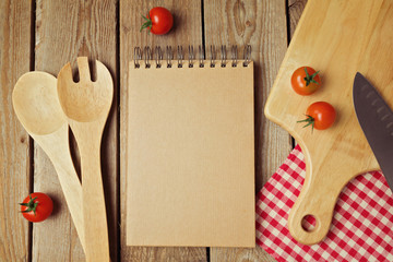 Cardboard notepad with kitchen utensils on wooden table