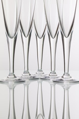 Five champagne glasses on a glass desk
