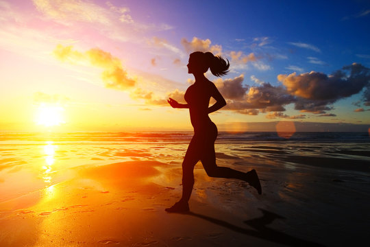 Running girl at sunset silhouette