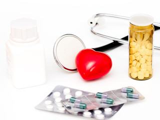 Herz mit Stethoskop und Tablettenpackungen