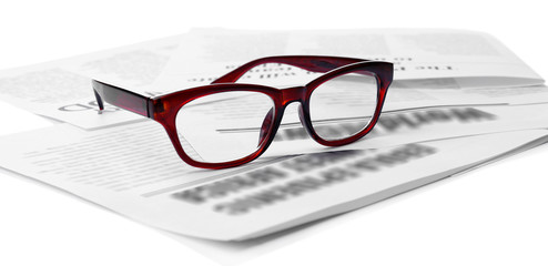 Glasses and newspapers, close-up