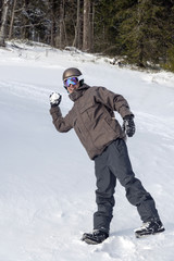 Fototapeta na wymiar Young man throwing a snowball