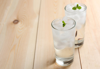 Glasses with ice cubes on wooden table