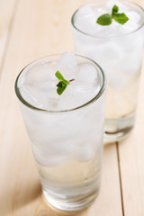 Glasses with ice cubes on wooden table