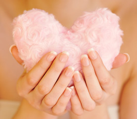 Fur pink heart in female hands