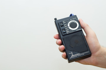 Portable retro radio receiver in hand.