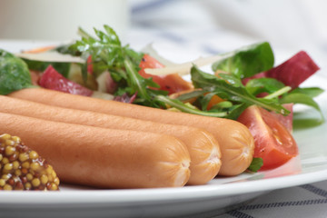 Wiener sausage with ketchup, mustard and salad.