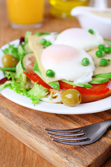 Sandwich with poached eggs, cheese and vegetables