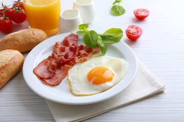Bacon and eggs on color wooden table background