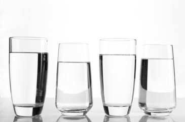 Glasses of water on light background