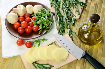 cheese, tomatoes and herbs on a kitchen table top view