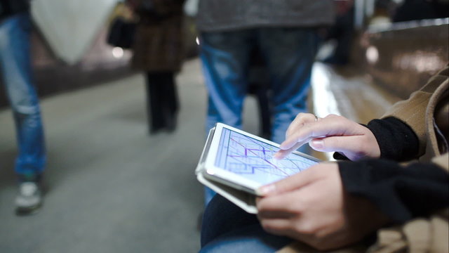 Woman in metro looking at undeground map on pad