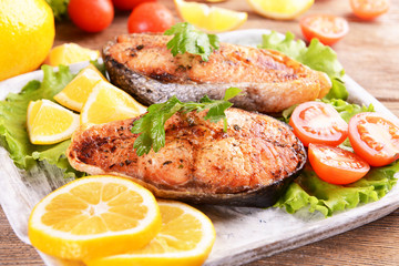 Tasty baked fish on plate on table close-up
