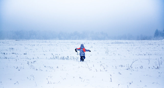 Little girl running away in a snowy park