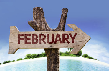 February wooden sign with a beach on background