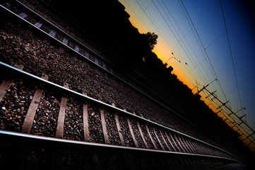 Railway tracks in sunset, city silhouette