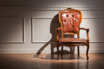 Brown classic arm-chair against the wall