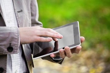 Men using digital tablet PC in the park.