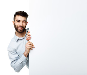 A young bearded man showing blank signboard, isolated over white