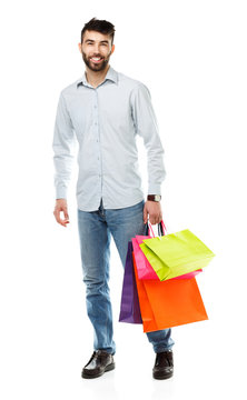 Handsome man holding shopping bags on white background