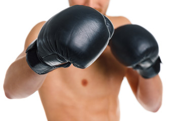 Athletic attractive man wearing boxing gloves on the white