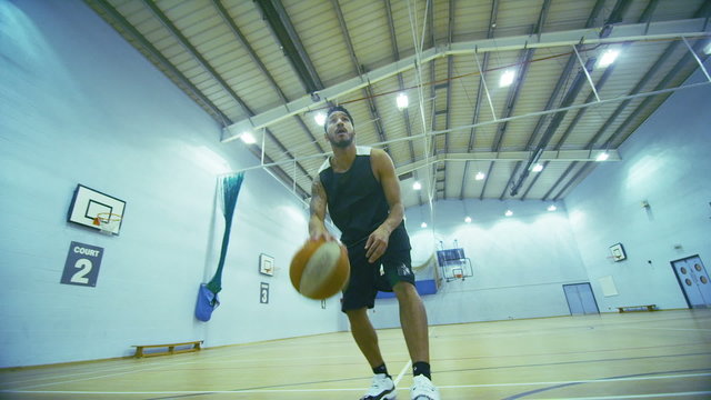 Mixed race basketball player dribbling the ball up the court
