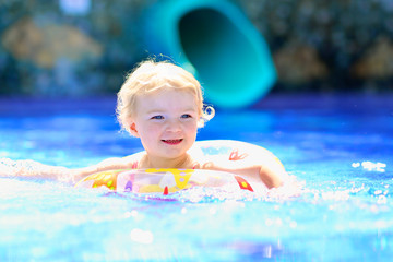 Fototapeta na wymiar Happy little girl having fun in swimming pool