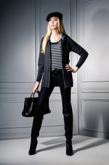 Full body portrait of fashion model holding bag posing