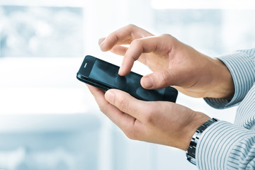 Close up of a man using mobile smart phone