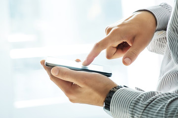 Close up of a man using mobile smart phone