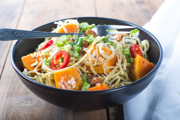 Bowl of pesto pasta with fresh vegetables