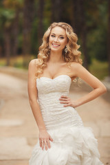 Fototapeta na wymiar Bride in wedding dress posing in the Park in the summer.
